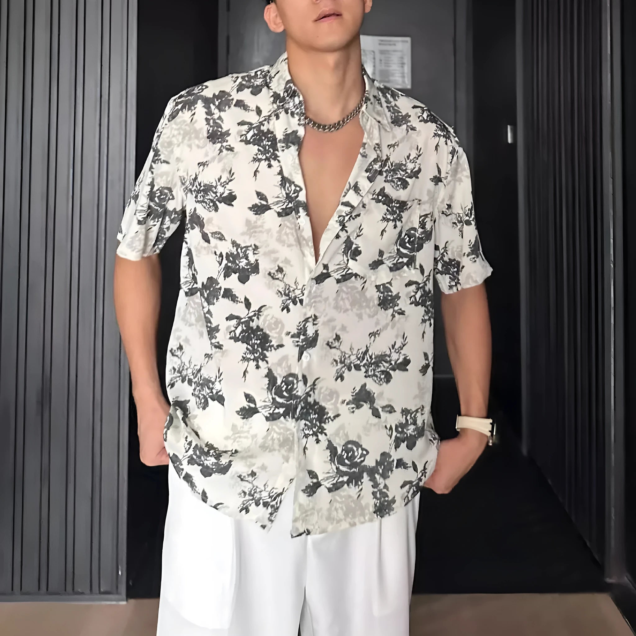 Loose-fitting black floral print short sleeve shirt on a hanger.