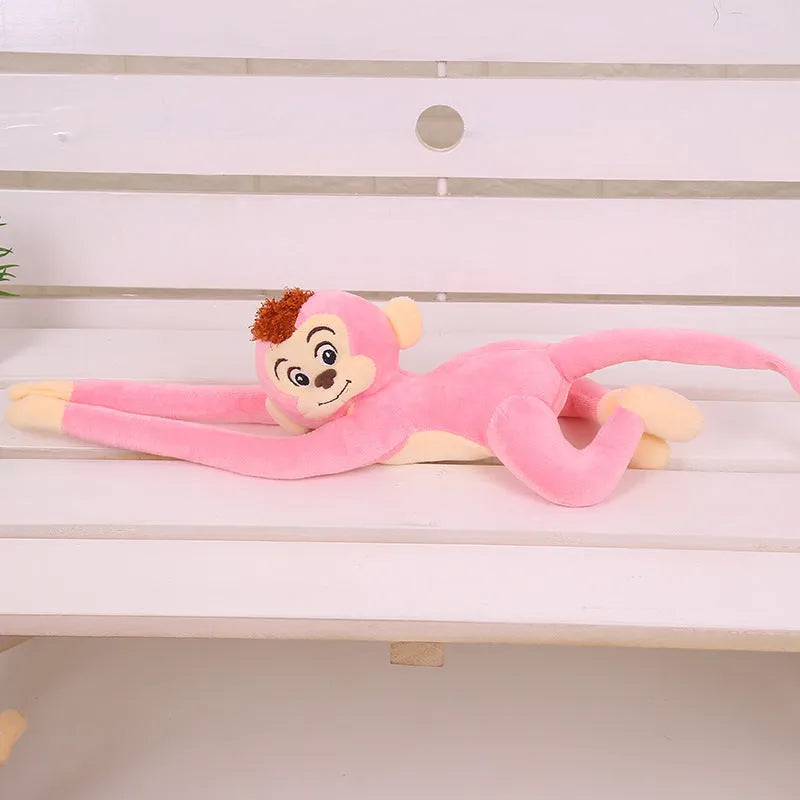 Long arm hanging monkey plush toy in pink, 70cm height, curled around a curtain rod for home decoration