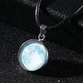 Luminous moon and star constellation pendant necklace with a silver-tone chain on a black background.
