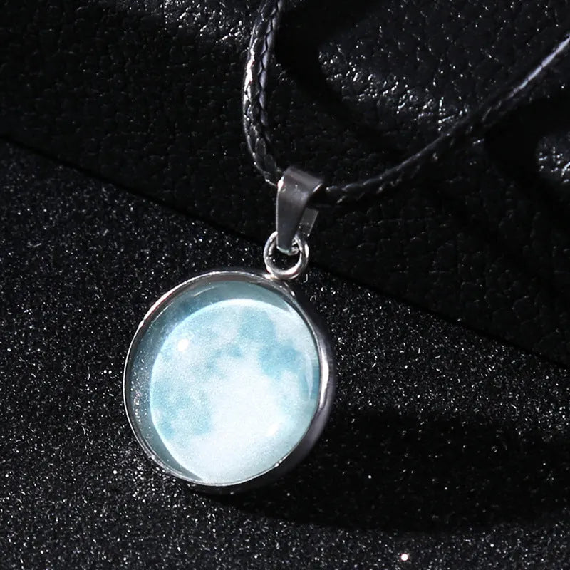 Luminous moon and star constellation pendant necklace with a silver-tone chain on a black background.