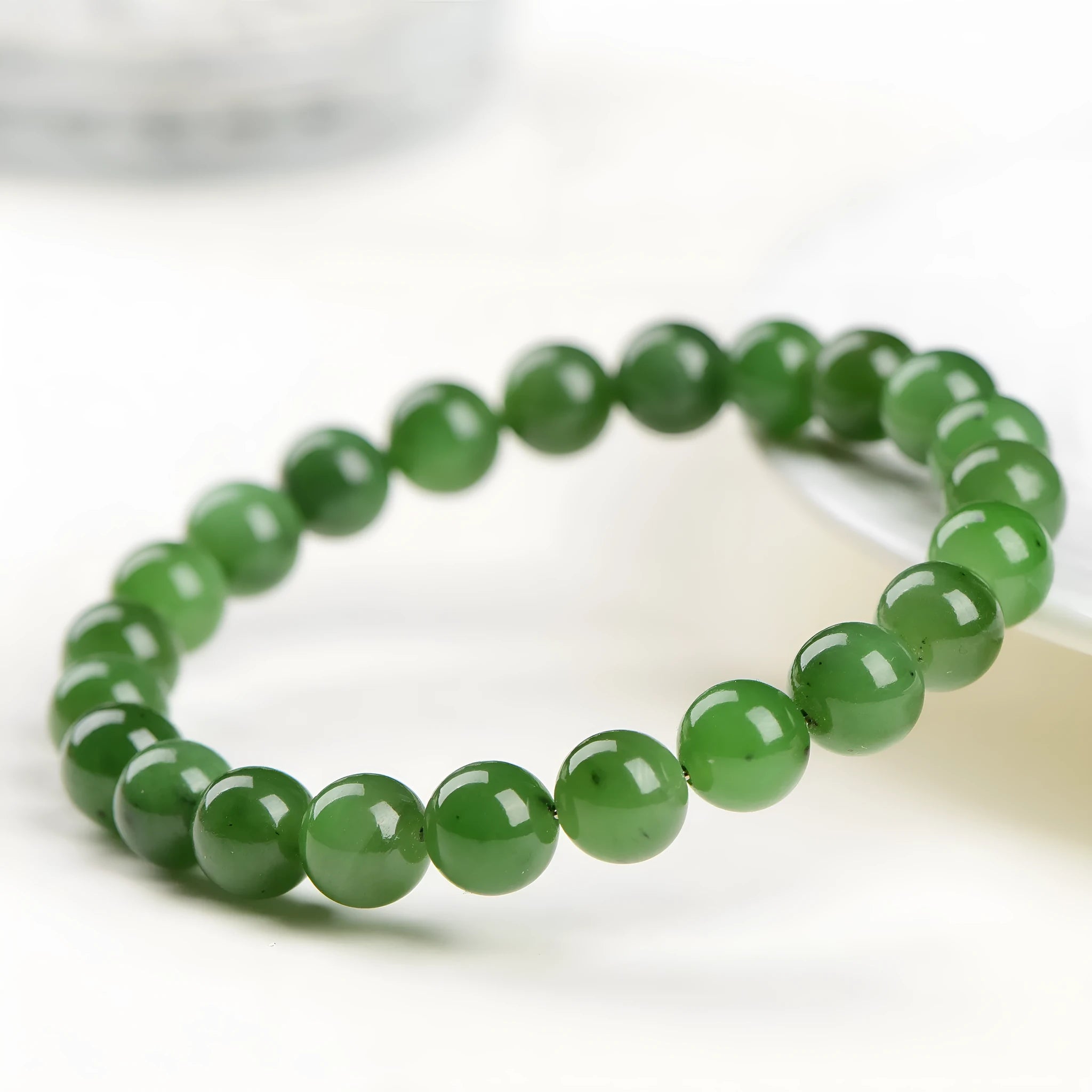 Natural Hetian jade jasper ball bracelet showing polished beads on a wrist.