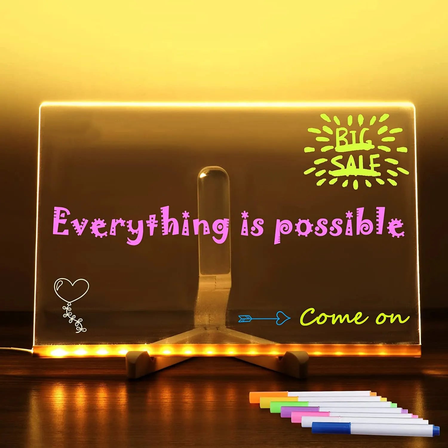 DIY acrylic message board LED night light on desk with colourful writing, USB cable, and pens