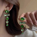 Retro green gradient geometric stud earrings with long silver tassel drop on a white background.