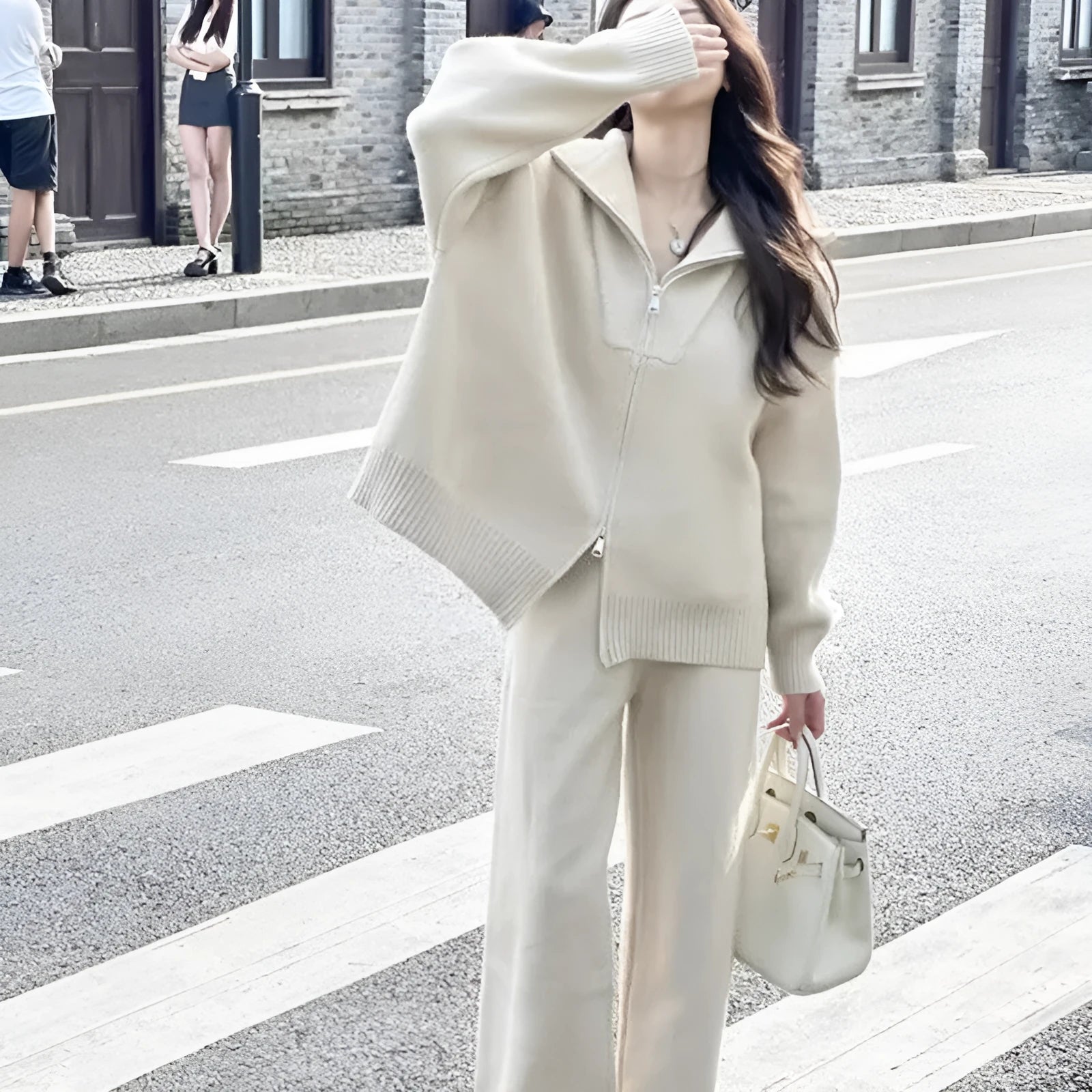 Solid colour knitted zip-front cardigan and wide-leg trousers two-piece set displayed in beige.