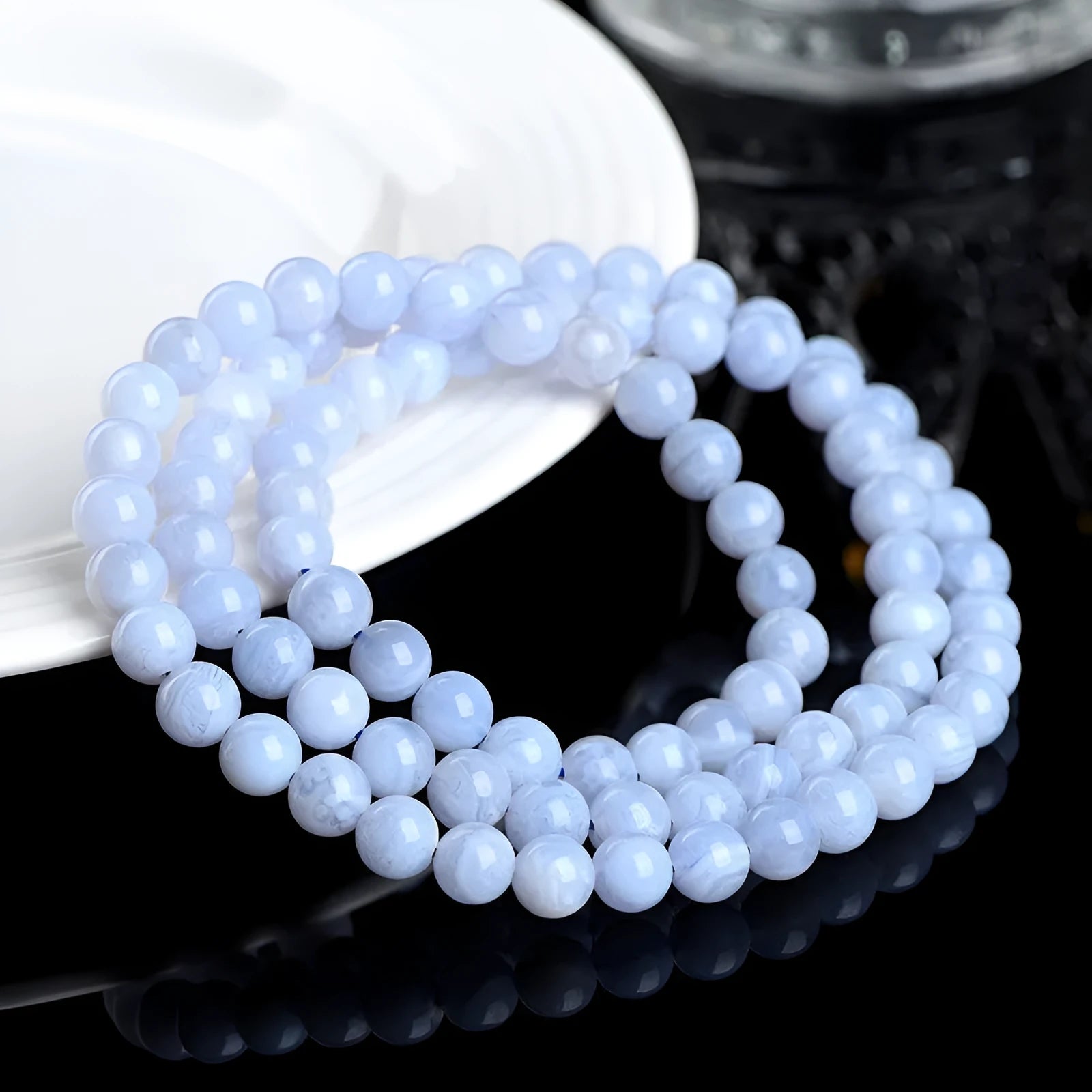 Close-up of a handmade blue agate bracelet with natural striped beads on a wrist.