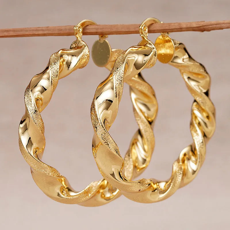 A pair of geometric design clip-on earrings for women with a drop shape and ring-and-line details.