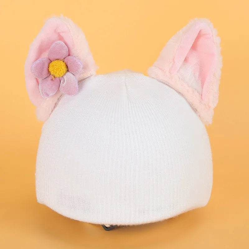 Colourful plush cartoon hat decoration sitting on top of a ski helmet