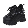 White women's low-top platform sports shoes with cross-strap detail on a rubber sole.
