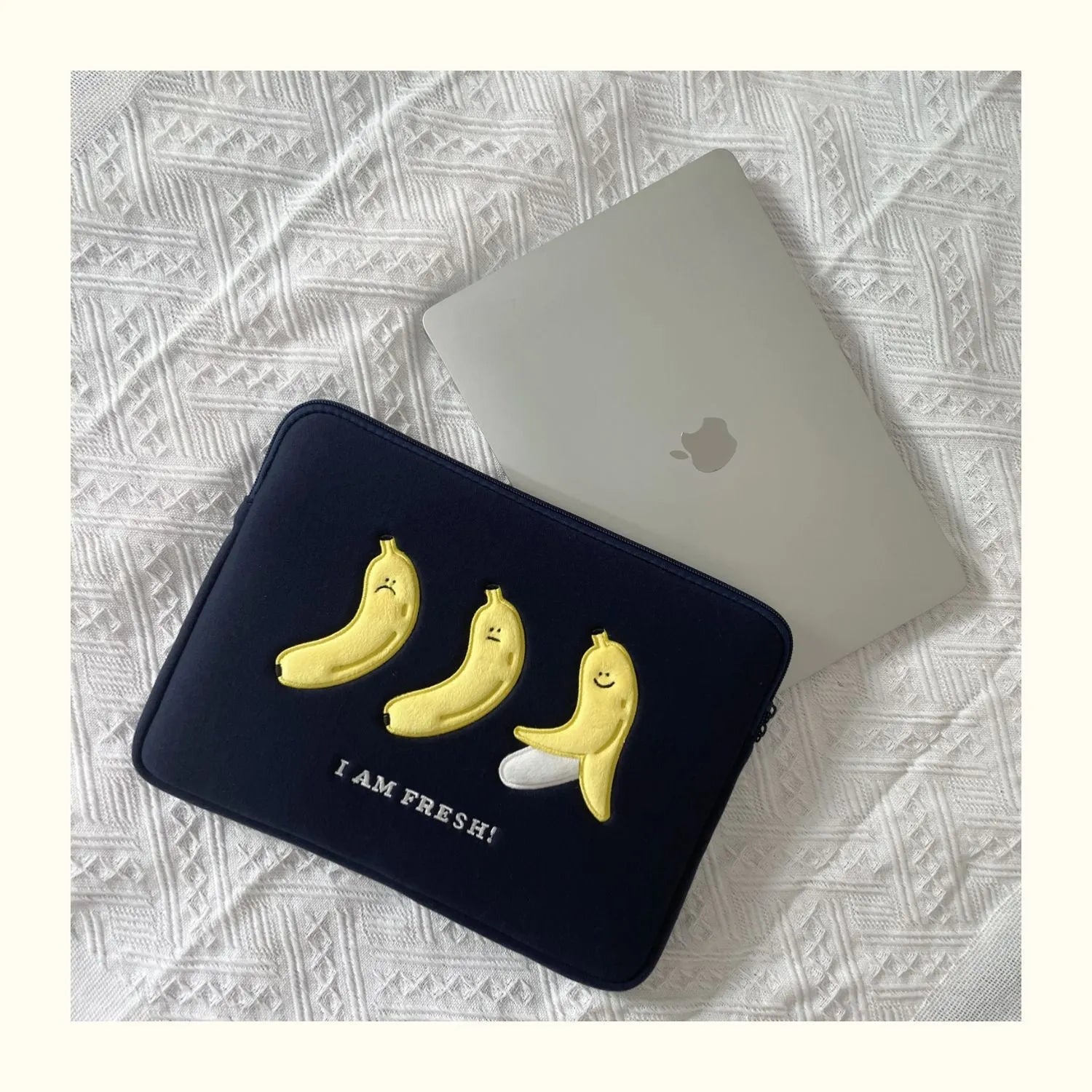 Embroidered animal design laptop sleeve in polyester, shown next to a laptop.