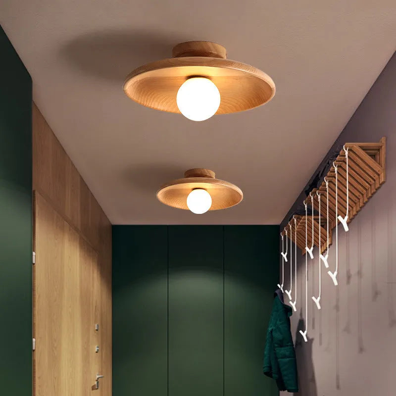 Modern minimalist solid wood and glass ceiling lamp in a hallway setting.