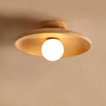Modern minimalist solid wood and glass ceiling lamp in a hallway setting.
