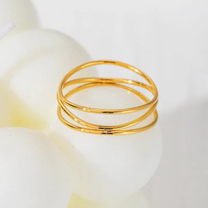 Gold-coloured titanium steel ring with a three-layer geometric coil band design.