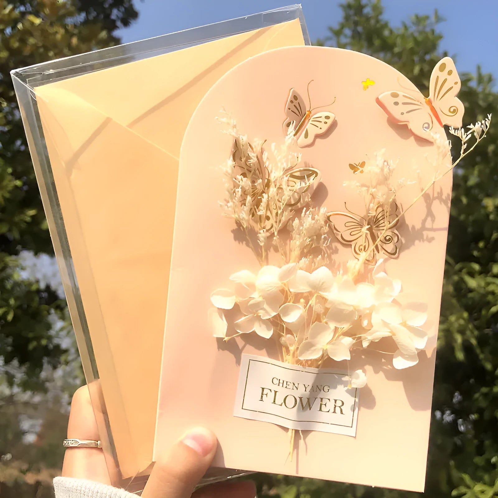 Handmade 3D butterfly-shaped birthday card with artificial flowers, shown with its matching envelope.