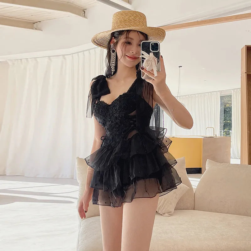 Black conservative one-piece women's swimsuit with gathered chest detail.