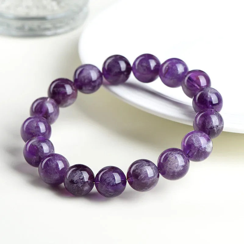 Natural feather amethyst bracelet with geometric Ruyi beads in snow mountain purple colour on a wrist.