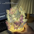 Handmade butterfly night light DIY kit with glass shade and raw wood base on a bedside table.