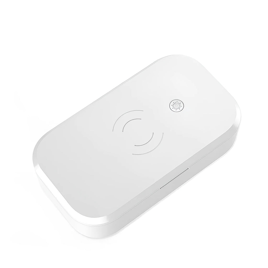 White ultraviolet disinfection box with wireless charging pad for mobile phones and beauty tools.