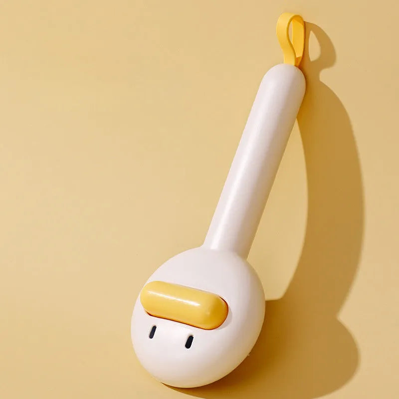 Small yellow duck-shaped pet grooming comb with open sections and needle bristles