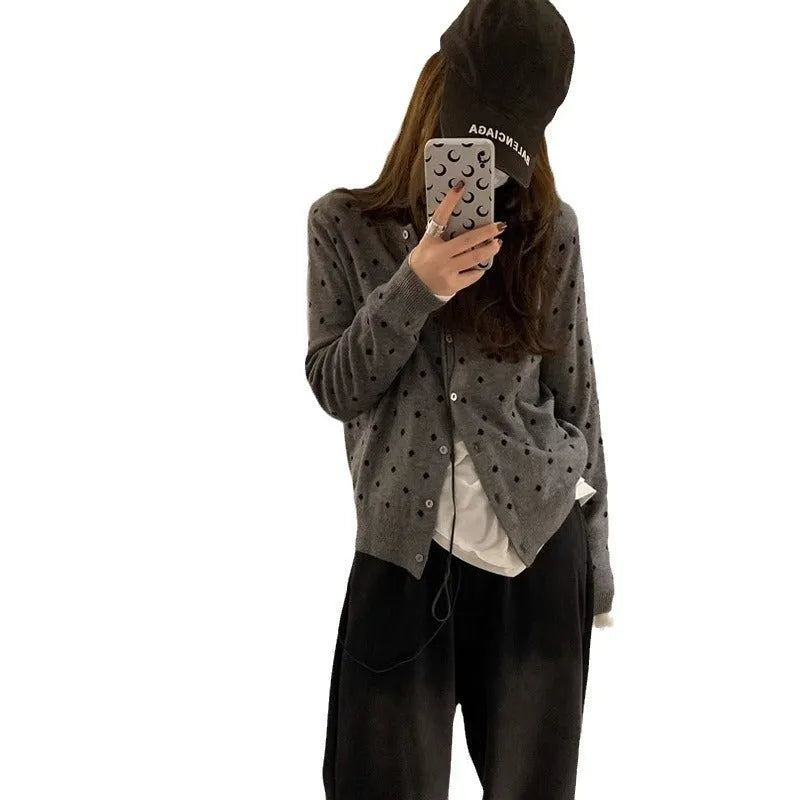 Women's grey dot knitted cardigan with crocheted flower detail on front, shown in loose fit.