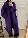Women's loose grey hooded cardigan coat with raglan sleeves on a hanger.