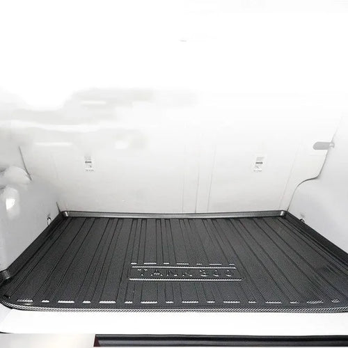 Black carbon fibre pattern TPE car trunk protector mat lying flat.