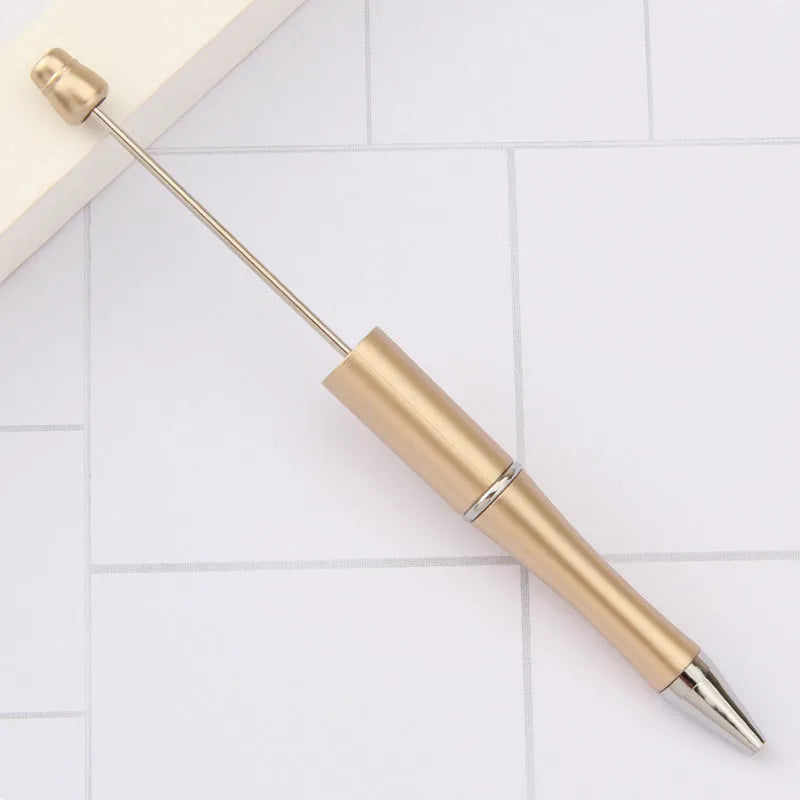 Colourful spinning ballpoint pen with plastic beads on a white background.