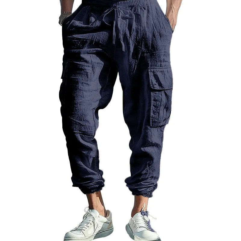 Men's solid colour linen trousers with ankle-tied cuffs, drawstring waist, and multiple pockets.