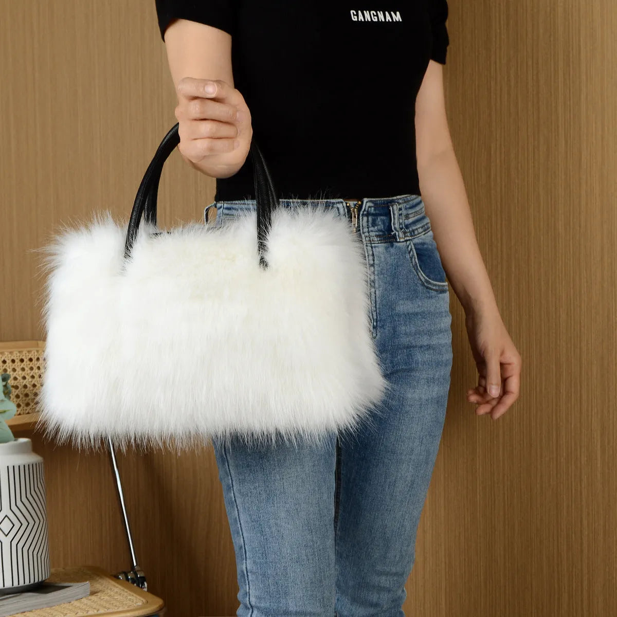 Hand-carrying square plush bag in pink with soft faux fur exterior and horizontal shape