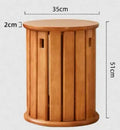 Stackable round iron dining stool in a modern style, shown in a choice of smoked black, walnut, cherrywood, or cream colour.