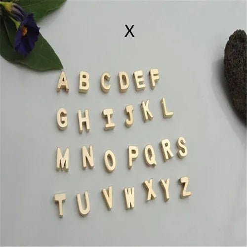 Gold alloy peach heart-shaped pendant featuring a single raised letter, shown from the front.