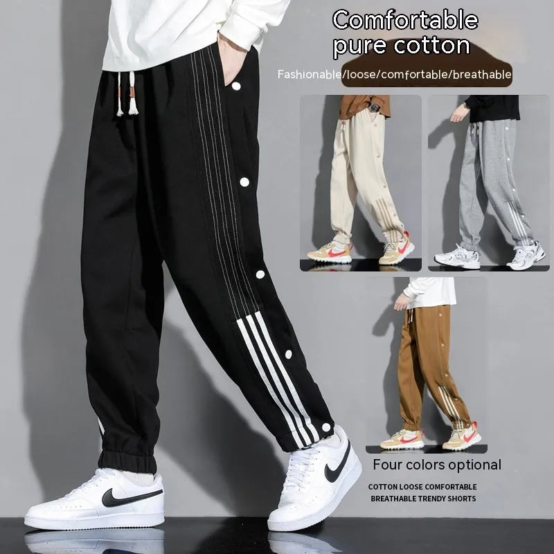 Men's black loose-fit ankle-tied sports trousers with high waist and drawstring closure on mannequin