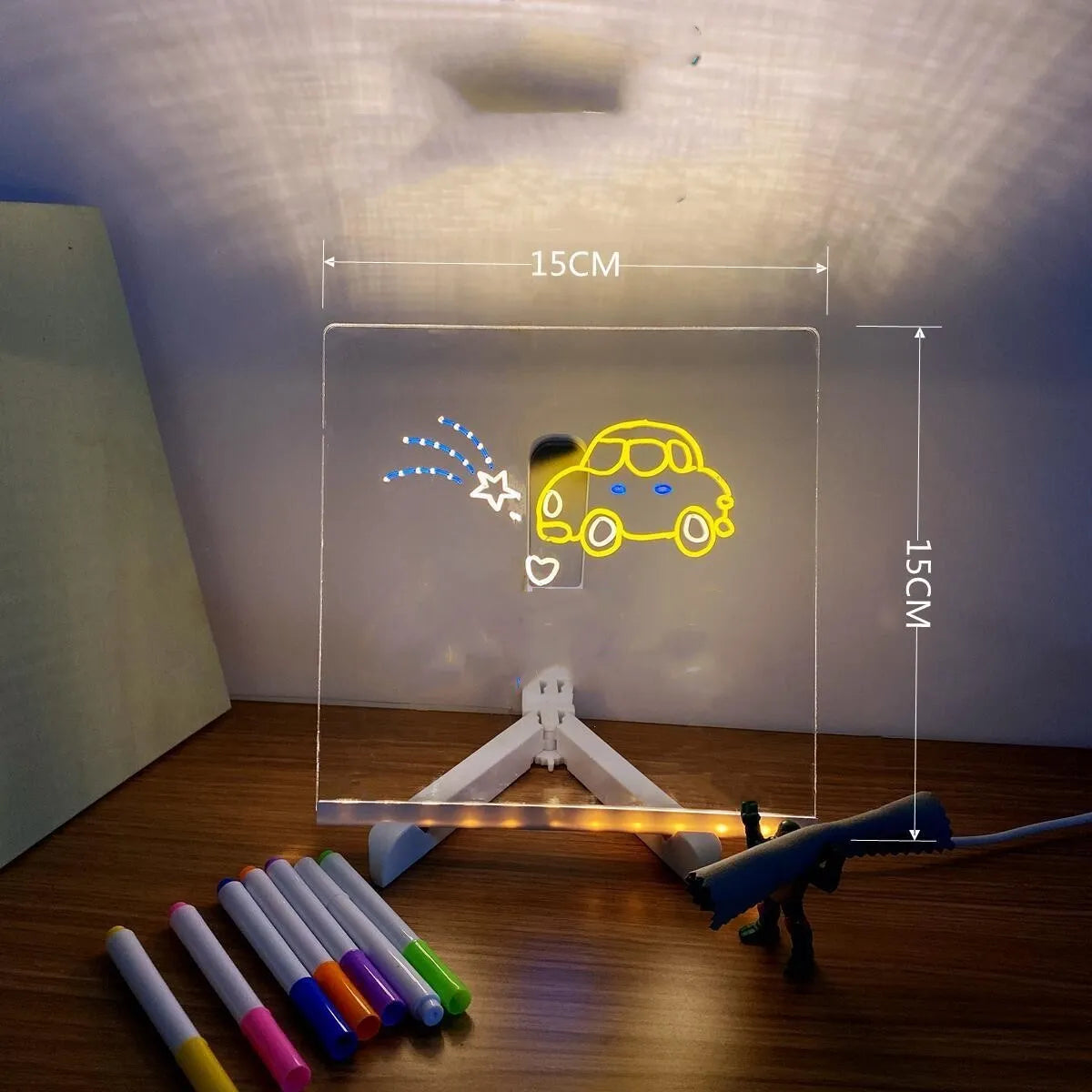 DIY acrylic message board LED night light on desk with colourful writing, USB cable, and pens