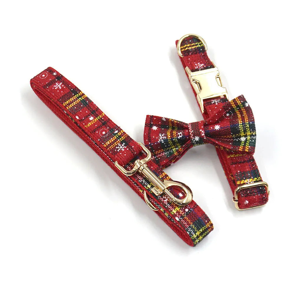 Red Christmas pet collar set with matching harness, leash, bow, and dog waste bag on cloth background