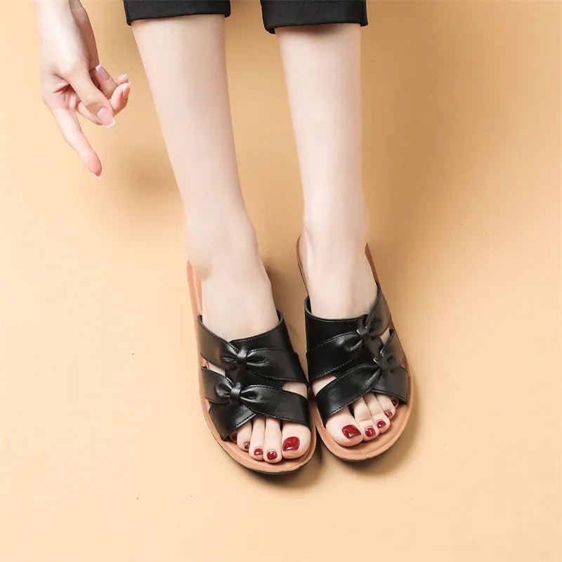 Beige women's cowhide slippers with a soft non-slip sole on a plain background