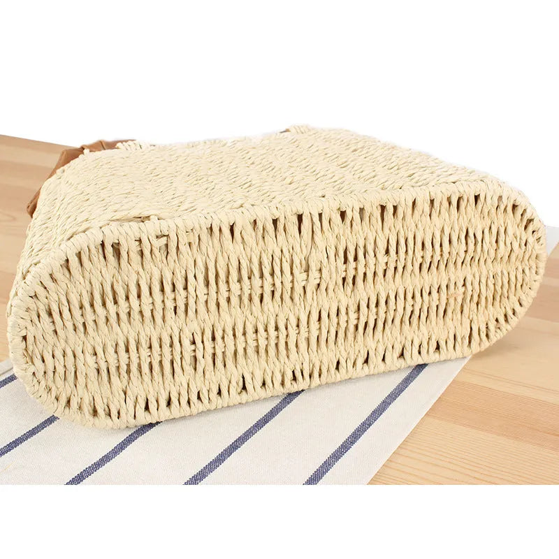 Portable woven straw bag in beige with hard trapezoid shape and double shoulder straps for seaside vacation daily use.