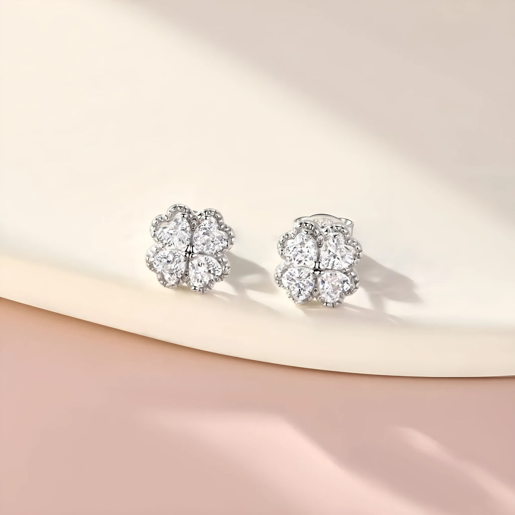 A pair of women's silver stud earrings with a four-leaf clover and heart design, white gold colour finish.