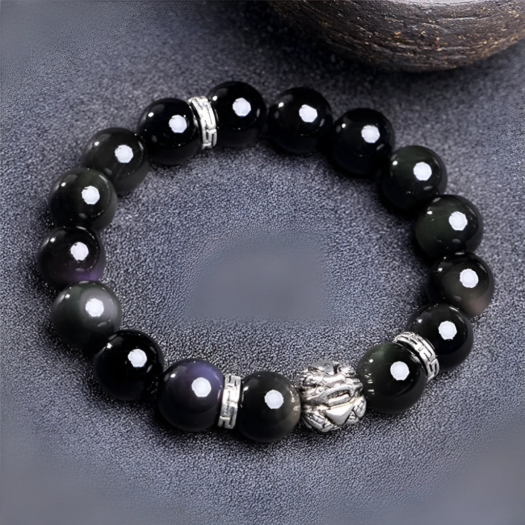 Obsidian unisex bracelet with silver detail in 10mm and 12mm bead size options on a wrist.