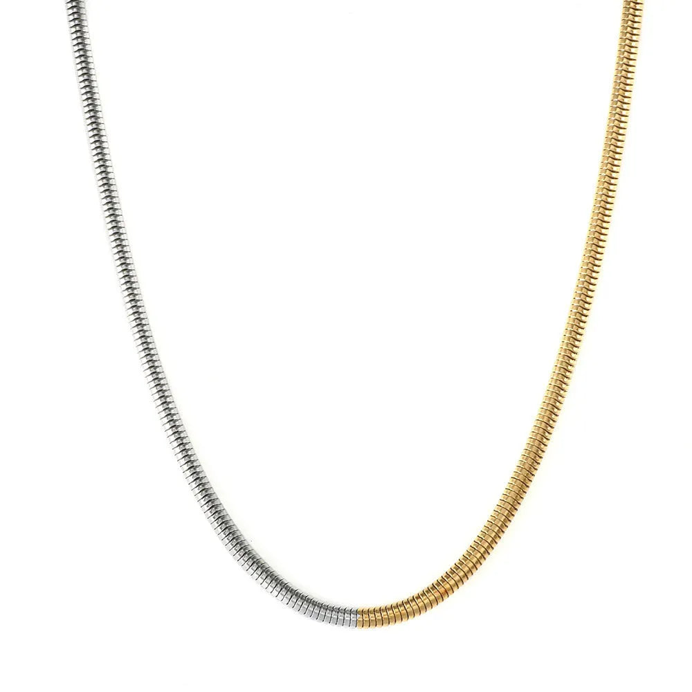 Gold-coloured geometric snake bone chain necklace for women on a white background, showing adjustable extender.