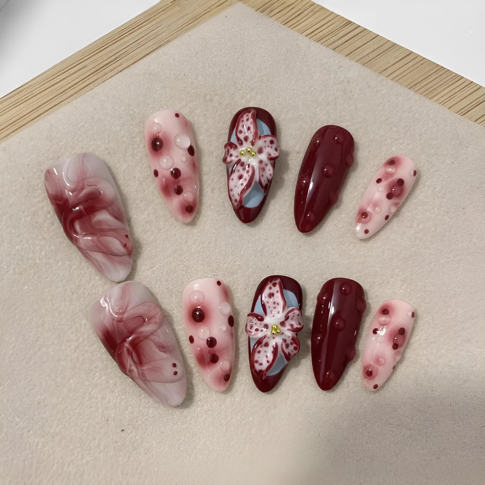 Hand-painted 3D carved manicure nail set showing rose, tulip and butterfly patterns in medium almond length