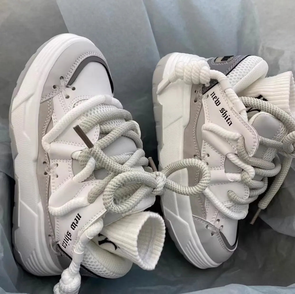 Women's grey retro chunky sneakers with thick sole and front lace-up, shown on a foot