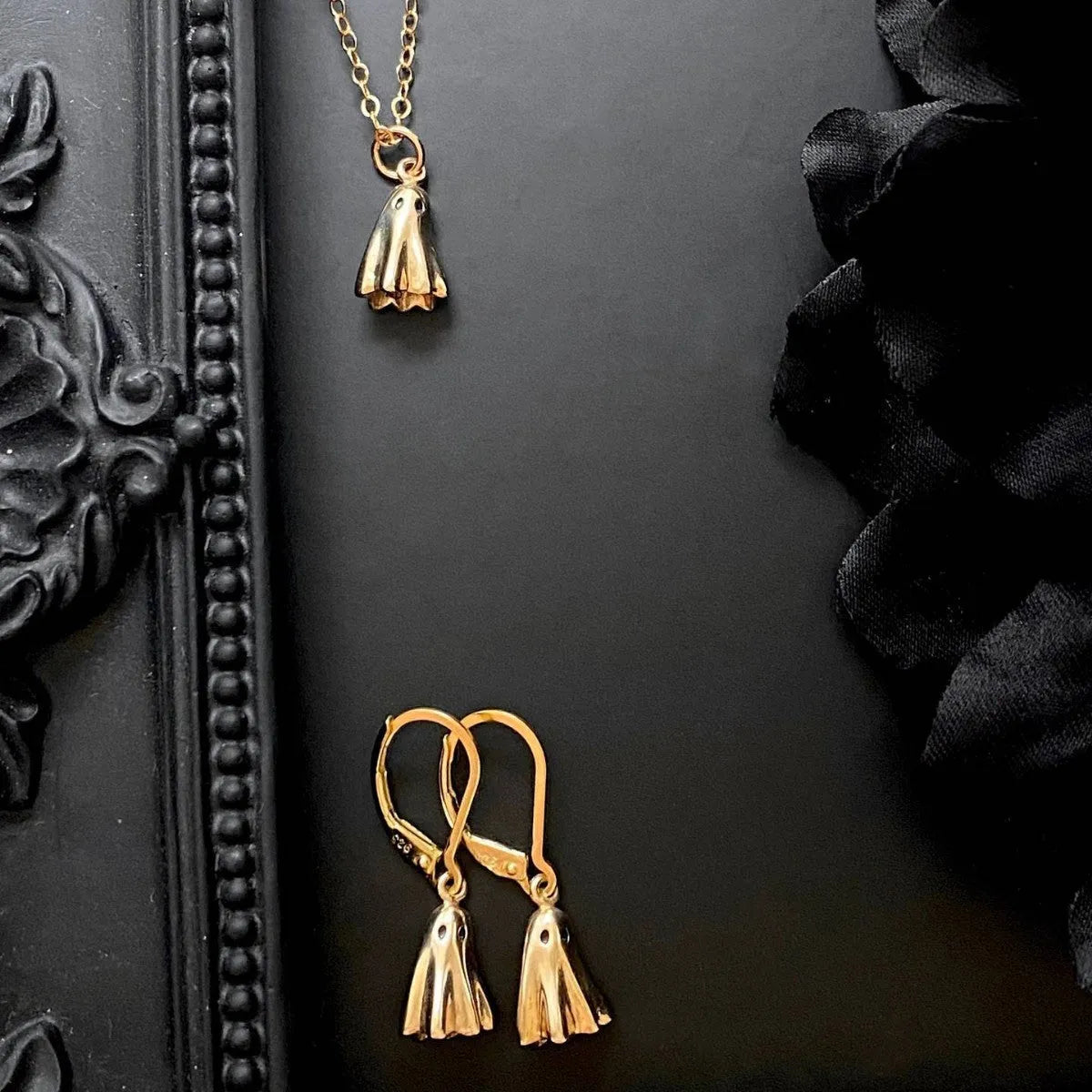 A modern ghost pendant necklace on a stainless steel chain, showing the titanium steel electroplated pendant detail.