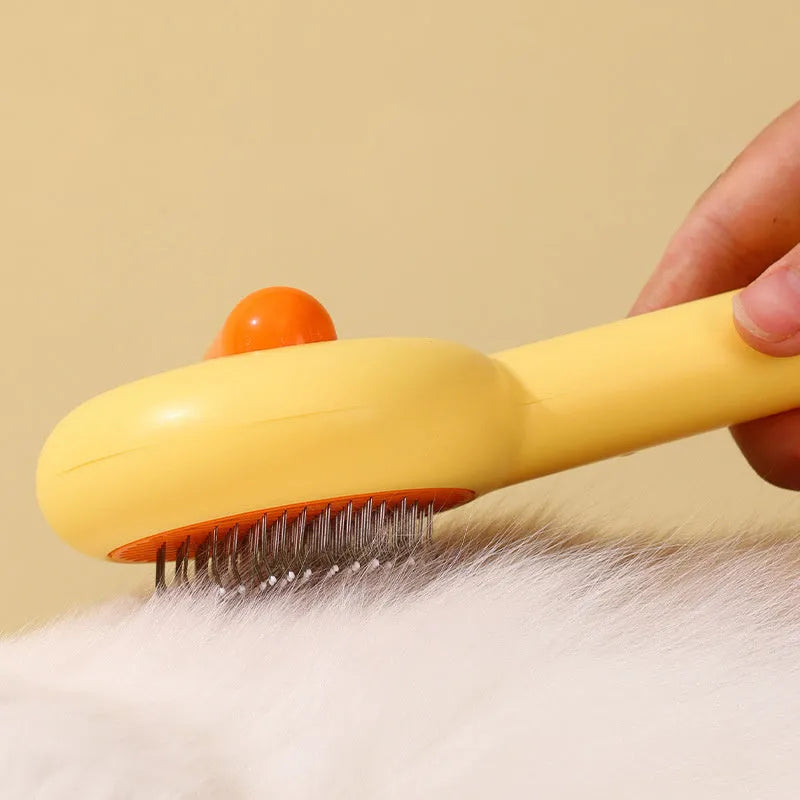 Small yellow duck-shaped pet grooming comb with open sections and needle bristles