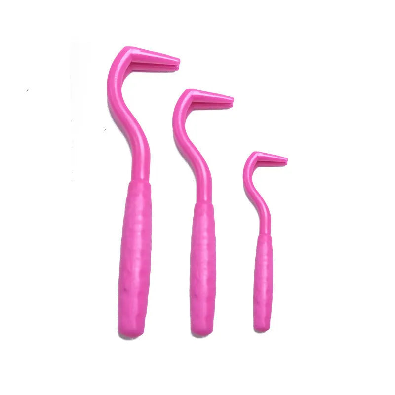 Pack of three coloured plastic tick removal hooks for dogs on a plain background.