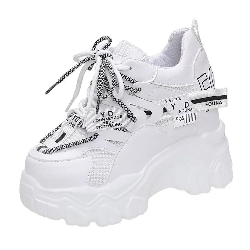 White women's low-top platform sports shoes with cross-strap detail on a rubber sole.