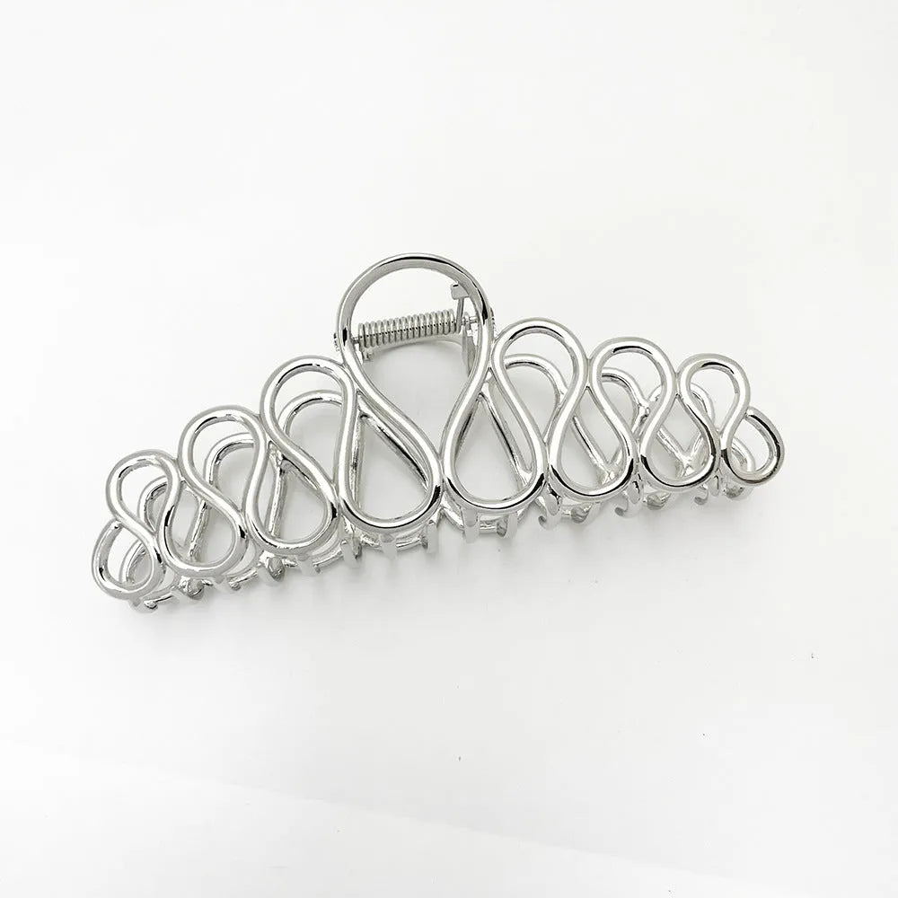 Minimalist large hair clip with gold electroplated finish and tassel detail on irregular geometric alloy design