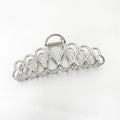 Minimalist large hair clip with gold electroplated finish and tassel detail on irregular geometric alloy design