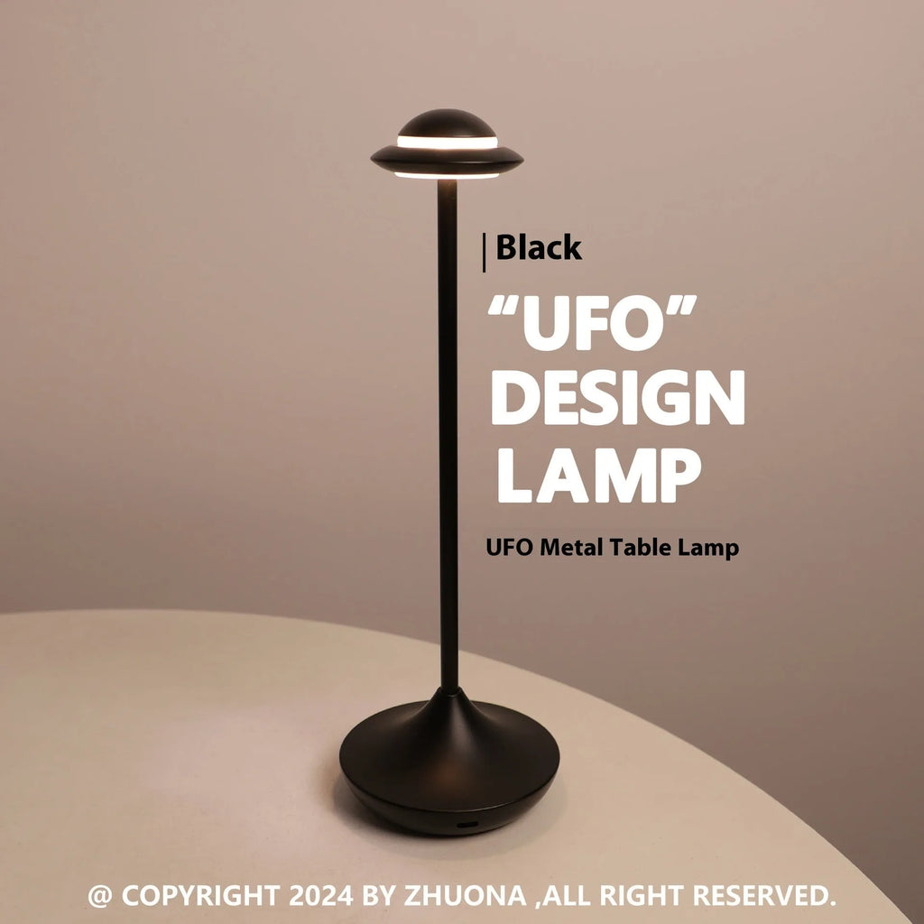 Modern UFO-shaped metal table lamp in black on a wooden desk, showing touch controls and soft glow.