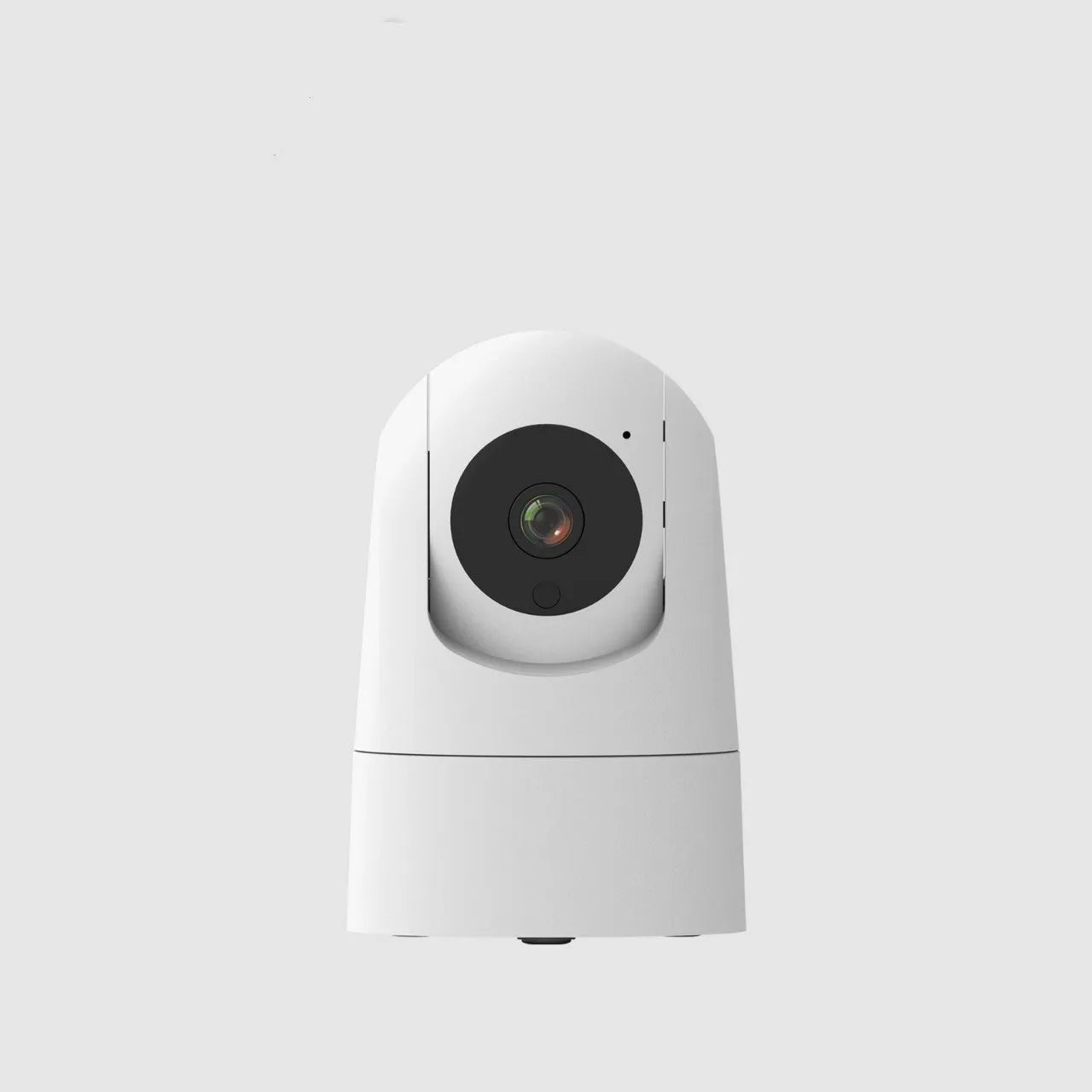 White indoor security camera with wide-angle lens on a table, showing power cable and mounting bracket.