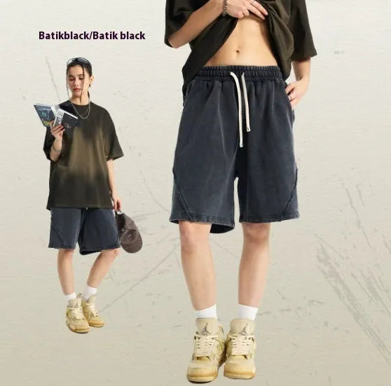 Man wearing batik-washed brown loose-fit cotton terry shorts on a casual street.