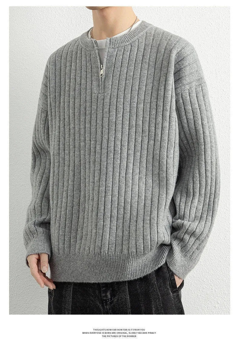 Man wearing a loose grey half-zip textured knit pullover sweater.